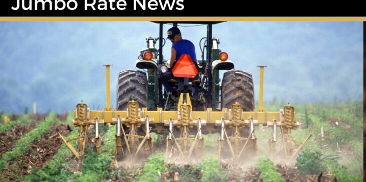 Farmer on a tractor with rows of plants behind